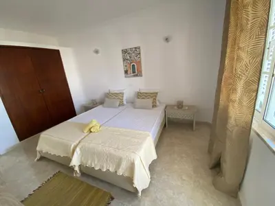a bedroom with a bed with a yellow towel on it at Moradia Olival- BBQ, 2 Quartos, Quintal in Albufeira