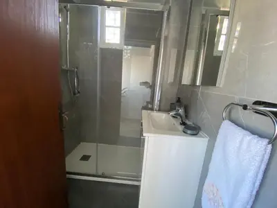 a bathroom with a shower and a sink and a mirror at Moradia Olival- BBQ, 2 Quartos, Quintal in Albufeira