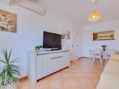 a living room with a tv on a white cabinet at AL - Apartamento Quinta do Romão in Quarteira