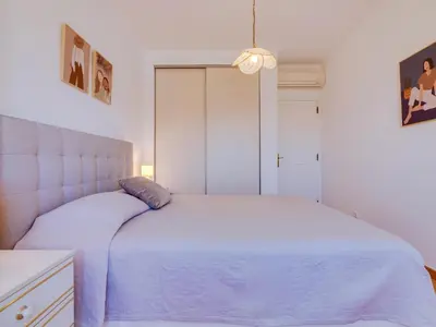 a white bedroom with a white bed with a blue blanket at AL - Apartamento Quinta do Romão in Quarteira