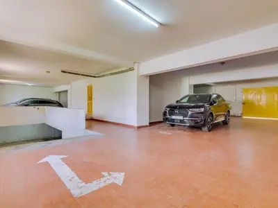 a garage with two cars parked in it at AL - Apartamento Quinta do Romão in Quarteira