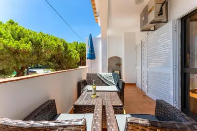 a table and chairs on a balcony with a view at Pine Trees Penthouse in Olhos de Água