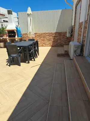 a patio with a table and chairs and a heater at Zurrinha holidays whit jacuzzi in Quarteira