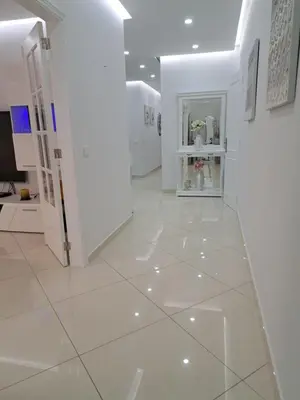 a hallway with white walls and a white tile floor at Zurrinha holidays whit jacuzzi in Quarteira