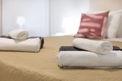 two stacks of towels sitting on top of a bed at Zurrinha holidays whit jacuzzi in Quarteira