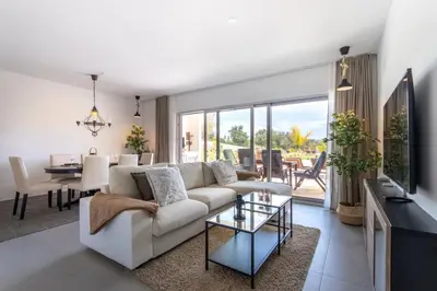 a living room with a white couch and a table at The Albufeira Concierge - Amazing Pool & Sunshine in Albufeira