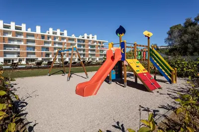 a playground in front of a large building at The Albufeira Concierge - Amazing Pool & Sunshine in Albufeira