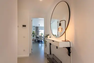 a mirror on a wall next to a vanity with a lamp at The Albufeira Concierge - Amazing Pool & Sunshine in Albufeira