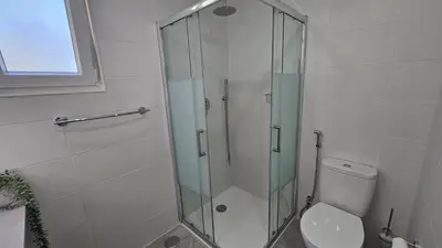 a bathroom with a glass shower and a toilet at Ocean View Beach Studio Old Town in Albufeira