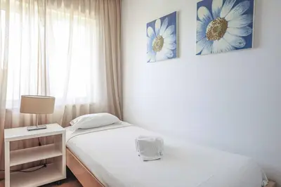 a small bedroom with two beds and a window at Villa Crispa in Albufeira