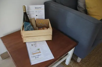 a bottle of wine on a table next to a couch at Sunny Days beach apartment in Quarteira