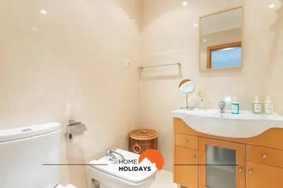 a bathroom with a toilet and a sink and a mirror at #154 V2 Vila Branca 54 by Home Holidays in Albufeira