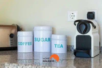 a kitchen counter with three cups and a coffee maker at #154 V2 Vila Branca 54 by Home Holidays in Albufeira
