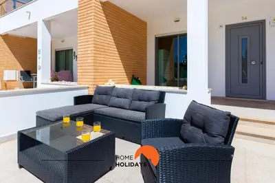 a patio with a couch and chairs and a table at #154 V2 Vila Branca 54 by Home Holidays in Albufeira