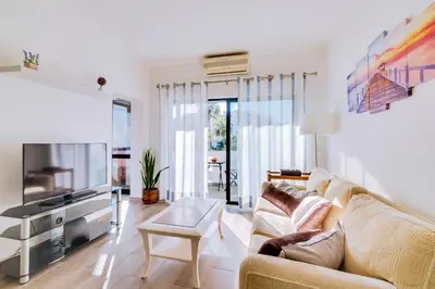 a living room with a couch and a tv at Apartamento Estrela do Mar in Quarteira