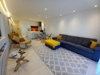 a living room with a blue couch and a kitchen at Sunlight Albufeira by Sunnyway in Albufeira