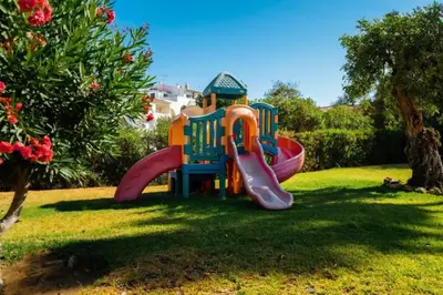 a playground with a slide in the grass at Sunlight Albufeira by Sunnyway in Albufeira