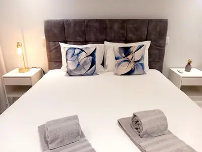 a bedroom with a large white bed with blue pillows at Sunlight Albufeira by Sunnyway in Albufeira