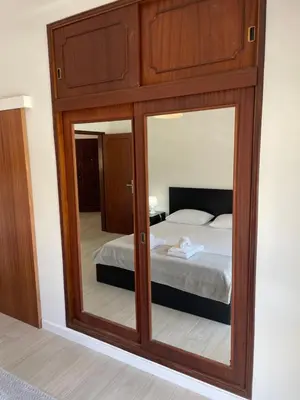 a bedroom with a bed and a large mirror at A Minha Praia in Quarteira