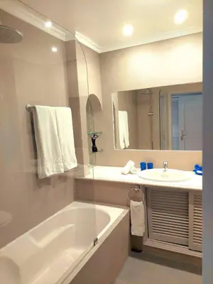 a bathroom with a bath tub and a sink at Seaside SunFlower in Quinta do Lago