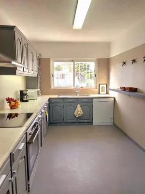 a large kitchen with gray cabinets and a window at Seaside SunFlower in Quinta do Lago