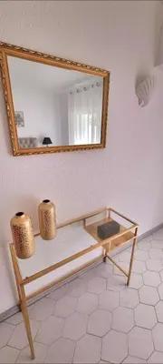 a mirror on a wall with a bench in a room at Seaside SunFlower in Quinta do Lago