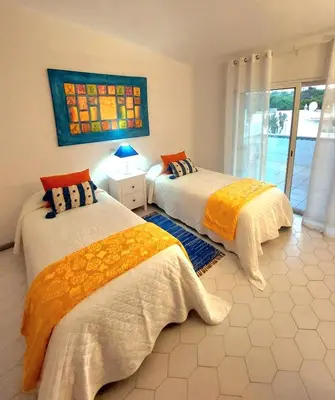 a bedroom with two beds and a window at Seaside SunFlower in Quinta do Lago