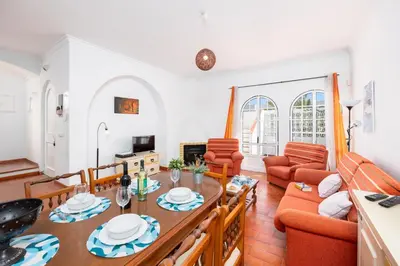 a swimming pool with chairs and an umbrella at Villa Lili in Albufeira