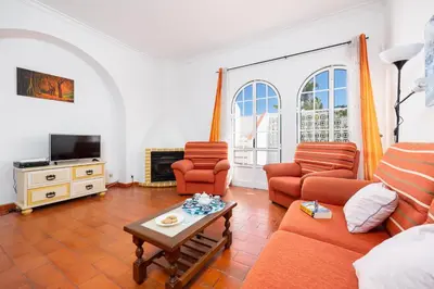 a living room with a couch and two chairs and a tv at Villa Lili in Albufeira