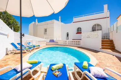 a villa with a swimming pool and lounge chairs at Villa Lili in Albufeira