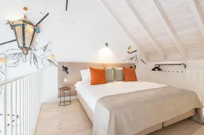 a bedroom with a large bed with orange pillows at LODO Suites Arco - Mezanino apartment by HD in Faro