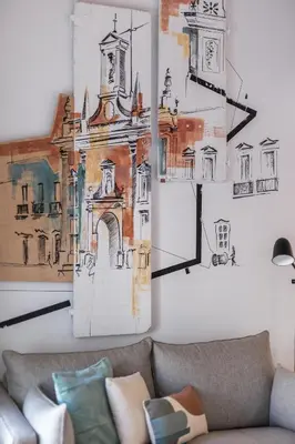 a living room with a couch and drawings on the wall at LODO Suites Arco - Mezanino apartment by HD in Faro