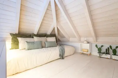 a bed in a room with a wooden ceiling at LODO Suites Ala - Studio mezanino by HD in Faro
