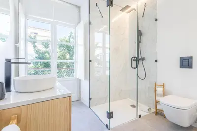 a bathroom with a shower and a sink and a toilet at LODO Suites Ala - Studio mezanino by HD in Faro