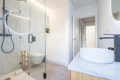 a bathroom with a sink and a glass shower at LODO Suites Ala - Studio mezanino by HD in Faro