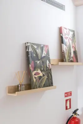 a shelf on a wall with some plants on it at LODO Suites Se - Mezanino room by HD in Faro