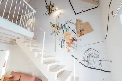 a staircase in a house with drawings on the wall at LODO Suites Se - Mezanino room by HD in Faro