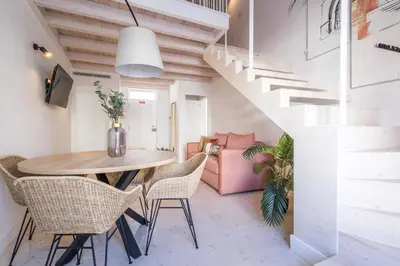 a dining room with a table and chairs and a staircase at LODO Suites Se - Mezanino room by HD in Faro