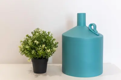 a blue bottle and a plant on a table at Privilege Apartment Aliança da Silva in the heart of Faro in Faro