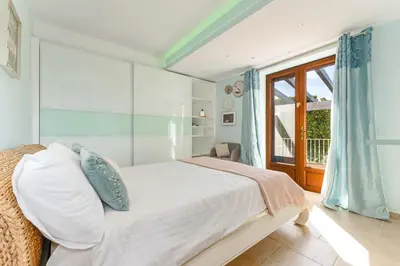 a white bedroom with a bed and a window at The Quinta - 3 Bedroom ensuite Villa, Swimming Pool, Beautiful Gardens, water features and lake in Almancil