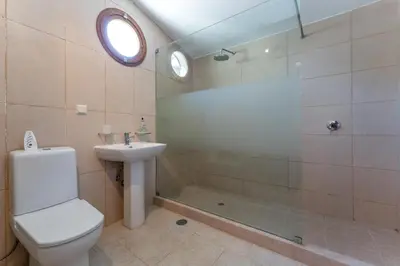a bathroom with a shower and a toilet and a sink at The Quinta - 3 Bedroom ensuite Villa, Swimming Pool, Beautiful Gardens, water features and lake in Almancil