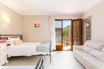 a bedroom with a bed and a couch at The Quinta - 3 Bedroom ensuite Villa, Swimming Pool, Beautiful Gardens, water features and lake in Almancil