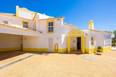 a patio with chairs and a table with a bottle of wine at Villa Brejos in Albufeira