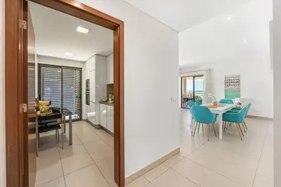 a dining room and kitchen with a table and chairs at Seaview Serenity with Pool & Garden in Quarteira