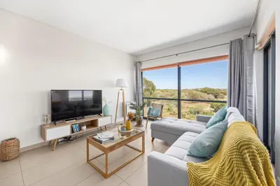 a living room with a couch and a tv at Seaview Serenity with Pool & Garden in Quarteira
