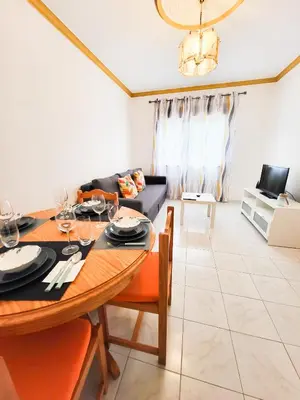 a living room with a table and a couch at T1 Largo Frente - Familiar in Quarteira