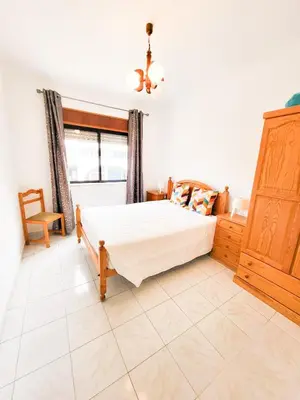 a bedroom with a large bed and a window at T1 Largo Frente - Familiar in Quarteira