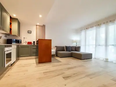 a living room with a couch and a kitchen at Solar dos Pinheiros in Vilamoura