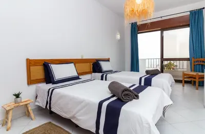 a bedroom with three beds with blue and white sheets at Old Town Apartment Panoramic NearThe Beach in Albufeira