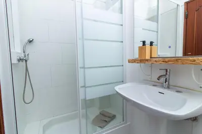 a white bathroom with a sink and a shower at Old Town Apartment Panoramic NearThe Beach in Albufeira
